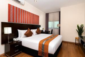 a hotel room with a large bed and a desk at Timor Plaza Hotel & Apartments in Dili +7 photos