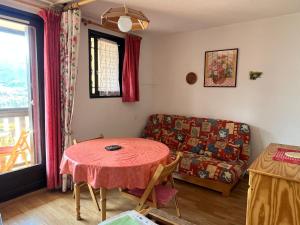 a living room with a table and a couch at Terrasse de l'Adroit - Barcelonnette - Wi-fi gratuit in Barcelonnette