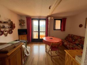 a living room with a table and a couch at Terrasse de l'Adroit - Barcelonnette - Wi-fi gratuit in Barcelonnette