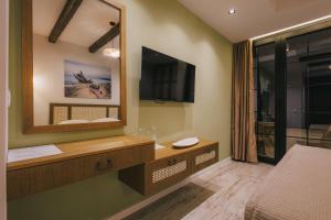 a bedroom with a large mirror and a television at Val D'or Olive Village in Ulcinj