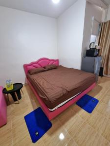 a bed in a room with blue mats on the floor at Nopphadon Hotel in Lat Krabang