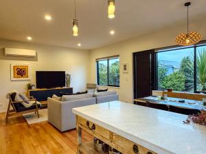 a living room with a couch and a table at Kowhai Cabin - Serene Scandi Escape in Hokitika in Hokitika