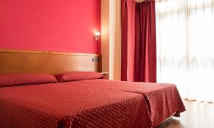a red bedroom with a bed with a red wall at Hotel Virgen de Covadonga in Cangas de Onís