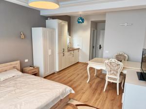 a bedroom with a bed and a desk and a table at Otopeni Garden Hotel in Otopeni
