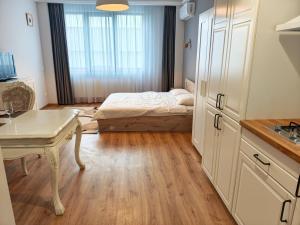 a bedroom with a bed and a kitchen with a table at Otopeni Garden Hotel in Otopeni +43 photos