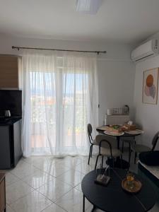 a living room with a table and a large window at The View Xanthi in Xanthi
