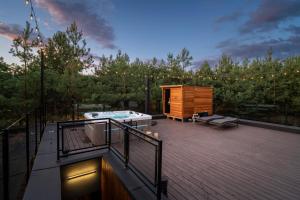 a deck with a hot tub and a bench on a deck at Dziupla House in Czarna