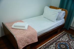 a small bed with two pillows on top of a table at Meyman House in Karakol