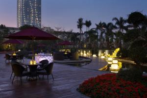 a patio with tables and umbrellas and a fire place at Wanda Realm Jiangmen in Jiangmen
