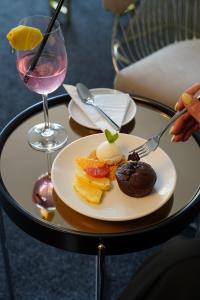 a table with a plate of food and a glass of wine at Parkside Boutique Hotel in Prishtinë
