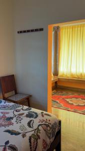 a bedroom with a bed and a window and a chair at Summer Beach House in Alleppey