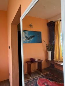 a mirror in a room with a table and a dolphin painting at Summer Beach House in Alleppey