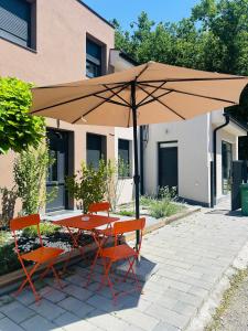a table and two chairs under an umbrella at Velora apartments in Subotica