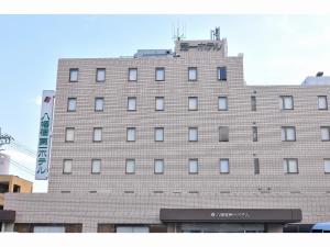 Un edificio alto con un cartel encima. en Yawatajuku Dai-ichi Hotel, en Ichihara