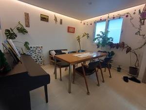 a dining room with a table and chairs at The upper room디어퍼룸 in Mahŭl-tong