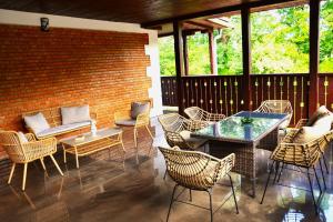 a patio with chairs and tables and a brick wall at Sándor János Villa in Sovata