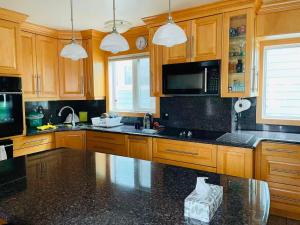 a kitchen with wooden cabinets and a black counter top at H on the bund in Saskatoon