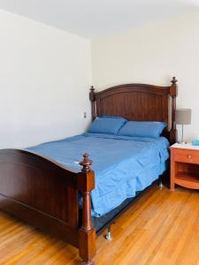 a bedroom with a wooden bed with blue sheets at H on the bund in Saskatoon