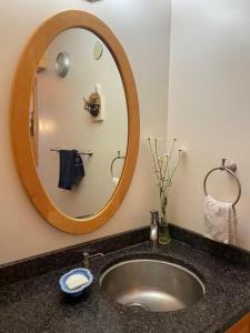 a bathroom sink with a large mirror above it at H on the bund in Saskatoon