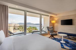 ein Hotelzimmer mit einem Bett und einem großen Fenster in der Unterkunft Radisson Blu Hotel Nice in Nizza