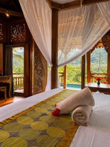 a bedroom with a bed with a towel on it at Alamdhari Villa Sidemen in Sidemen
