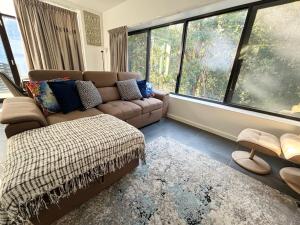 a living room with a couch and large windows at Nineteen On Gregory G02 in South West Rocks