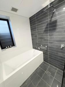 a bathroom with a bath tub and a window at Nineteen On Gregory G02 in South West Rocks +13 photos