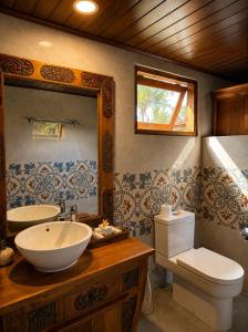 a bathroom with a sink and a toilet and a mirror at Alamdhari Villa Sidemen in Sidemen +33 photos