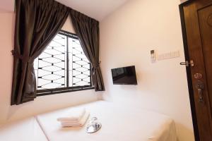 a bedroom with a bed and a window at HomeStay 21 Hotel in Johor Bahru