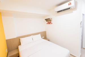 a small bedroom with a white bed and a tv at HomeStay 21 Hotel in Johor Bahru