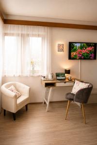 a room with a desk and a chair and a computer at Haus Rose in Allensbach