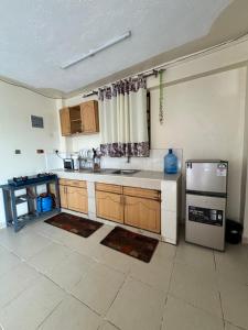 a kitchen with a sink and a refrigerator at The Homely Retreat in Thika