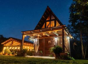 a house with a pergola lit up at night at Sp Atmatla Zacatlan Cabins in Zacatlán