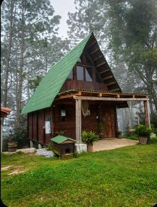 a small wooden house with a green roof at Sp Atmatla Zacatlan Cabins in Zacatlán +1 photo