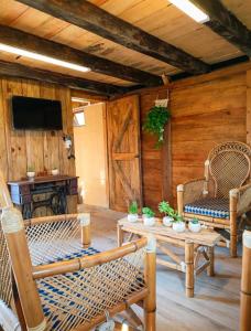 a living room with wicker chairs and a table at Sp Atmatla Zacatlan Cabins in Zacatlán
