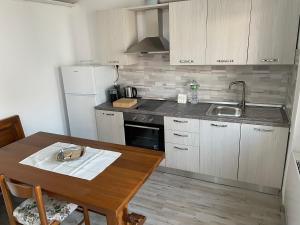 a kitchen with a table and a sink and a refrigerator at The River in Fordongianus