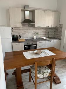 a kitchen with a wooden table and a counter top at The River in Fordongianus