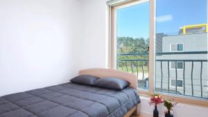 a bedroom with a bed and a large window at Samcheok Jisu Pension in Samcheok
