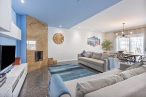 a living room with a couch and a tv at Beach Sunset - Apartment Ocean in Vila Nova de Gaia