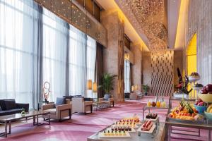 a lobby of a hotel with tables with fruit on them at Wanda Realm Jiangmen in Jiangmen