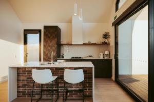 a kitchen with a counter and two stools at Glenbosch - Cottage One in Beechworth