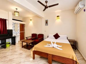 a bedroom with a bed with a towel on it at Morjim Sunset Guesthouse- Apartments with Kitchen & AC Rooms in Morjim