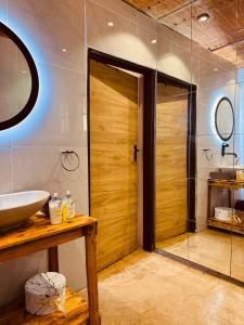 a bathroom with a shower and a wooden door at Siki's Cactus Hideaway in Mmokolodi +24 photos