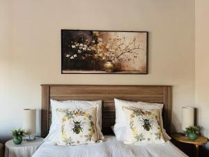 a bedroom with a bed with a painting on the wall at Siki's Cactus Hideaway in Mmokolodi