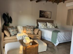 a living room with a bed and a couch at Siki's Cactus Hideaway in Mmokolodi