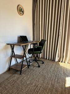 a desk with a laptop and a chair in a room at Siki's Cactus Hideaway in Mmokolodi