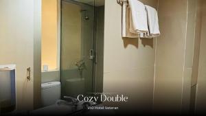 a bathroom with a toilet and a glass shower at Vio Veteran in Bandung +21 photos