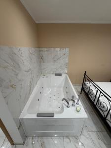 a white bath tub in a bathroom with marble walls at La Dolce Vita in Piran +18 photos