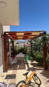 Ein orangefarbenes Fahrrad steht auf einer Terrasse mit Tisch und Stühlen. in der Unterkunft Jerash Villa For Rental in Gerasa