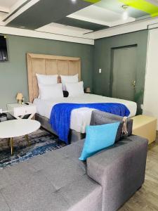 a bedroom with a large bed and a couch at R&N Hosts Mokhotlong in Mokoeng